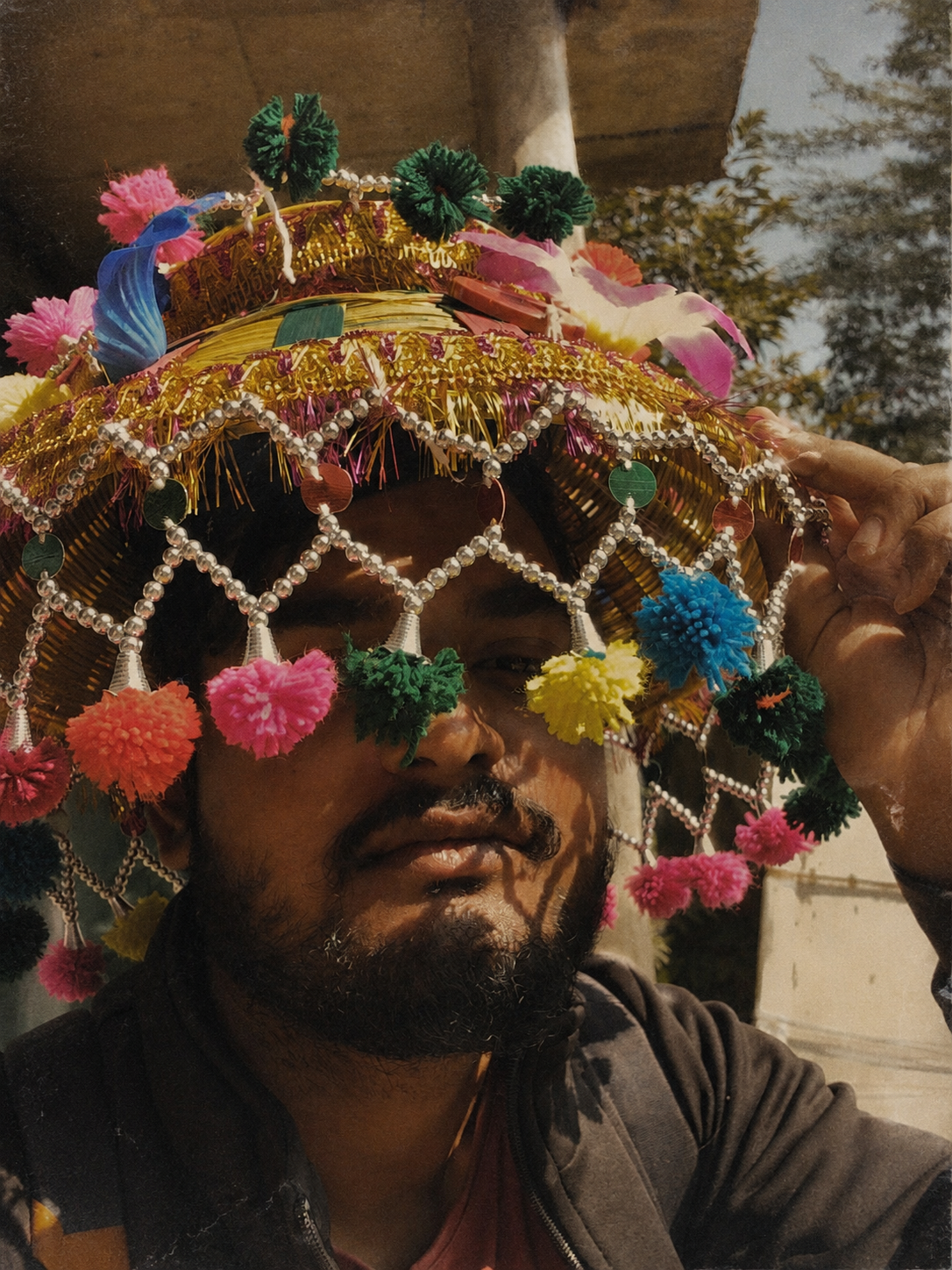 Anindya Singh wearing a colourful ceremonial hat outdoors