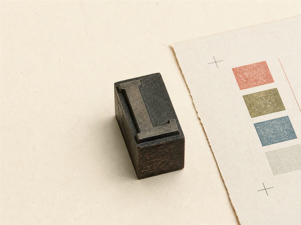 A letterpress block beside a simple registration proof